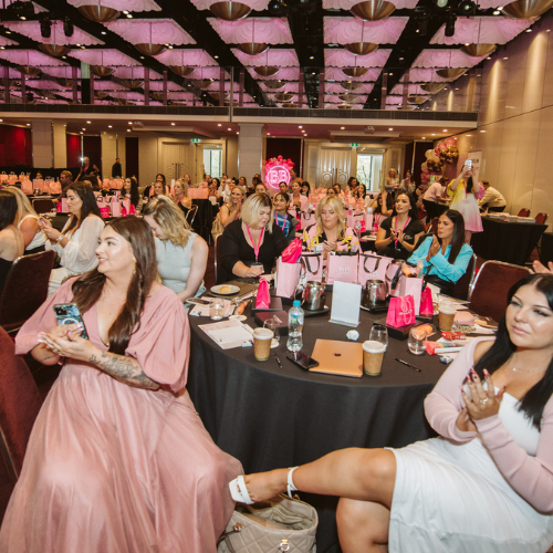 A large group of attendees at a makeup artist conference, focusing on certified makeup artist online course US.