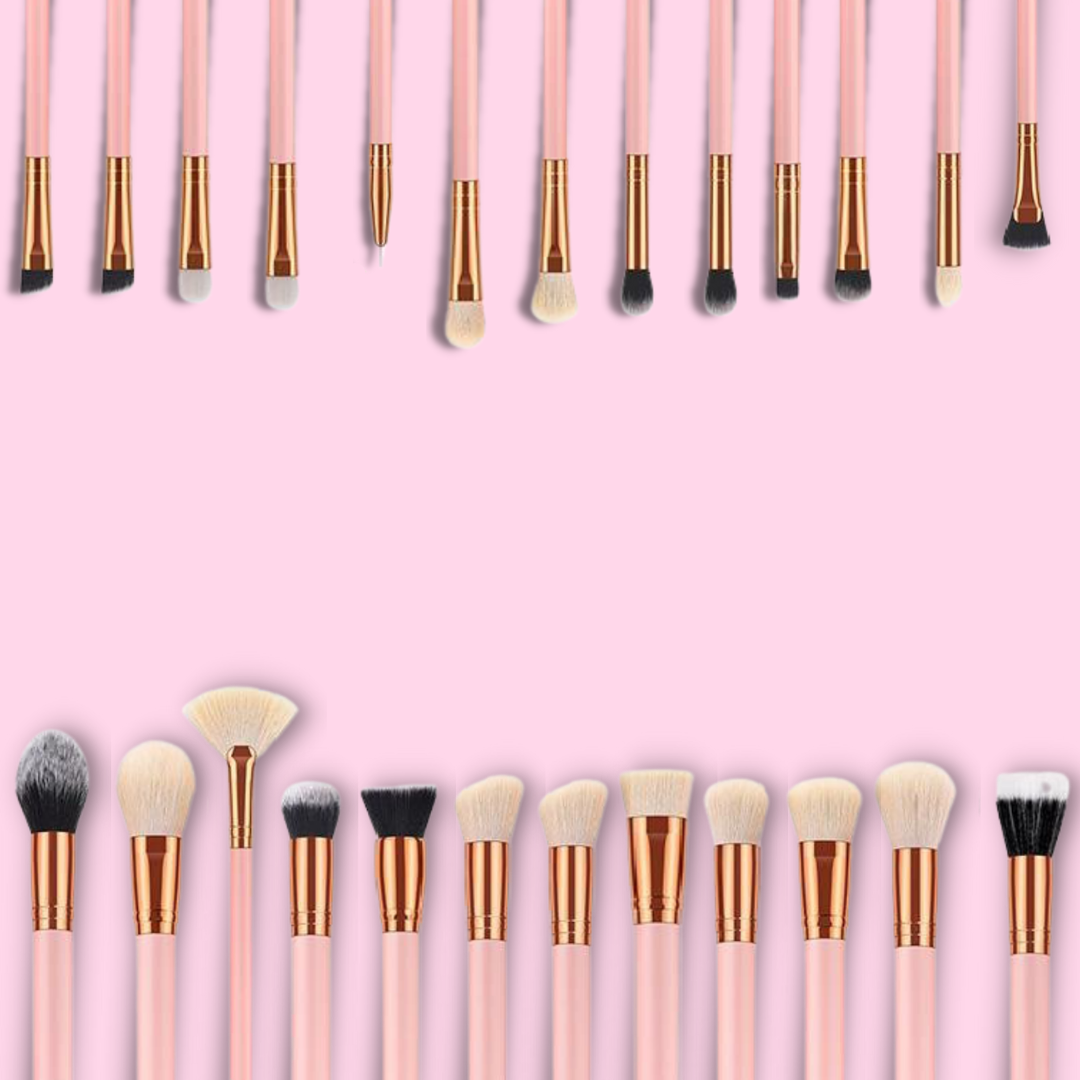 Various makeup brushes displayed on a pink background for a comprehensive makeup brushes guide.