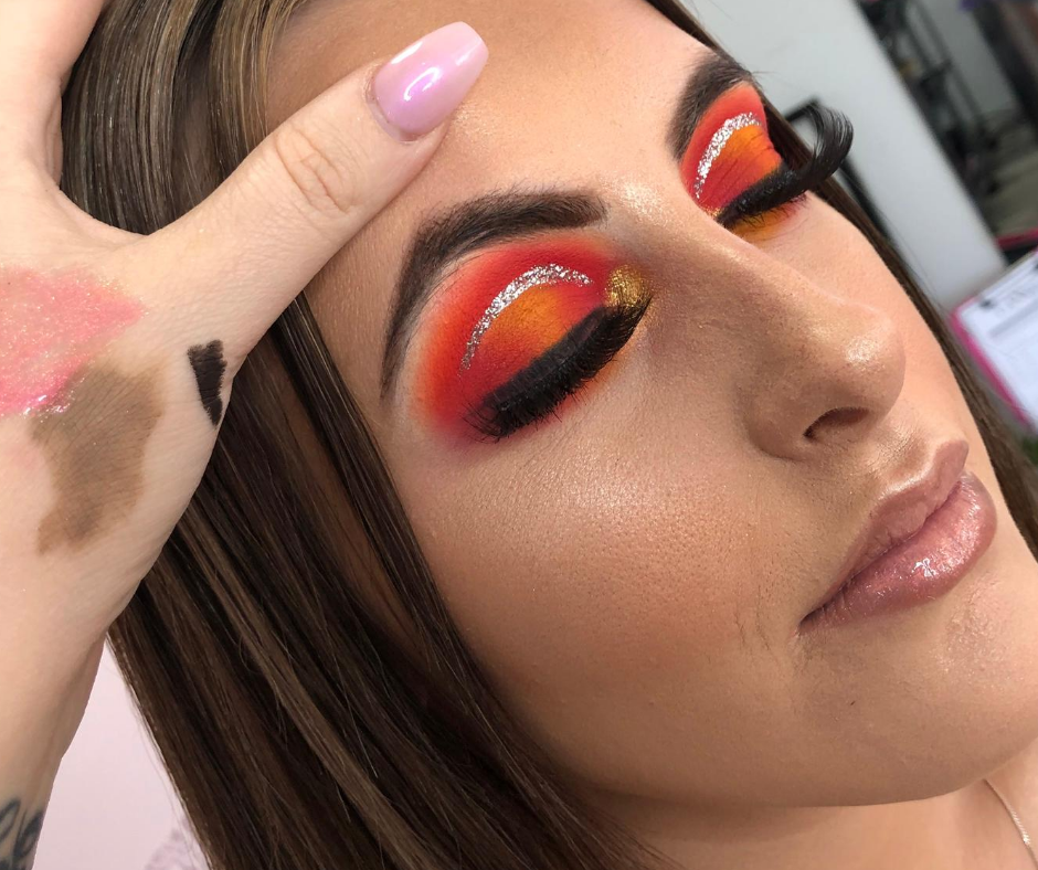 Makeup Masterclass model showcasing vibrant eye makeup with bold orange and gold hues, perfect for learning techniques.